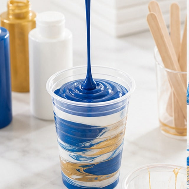 Pouring acrylic paint into a cup for fluid art